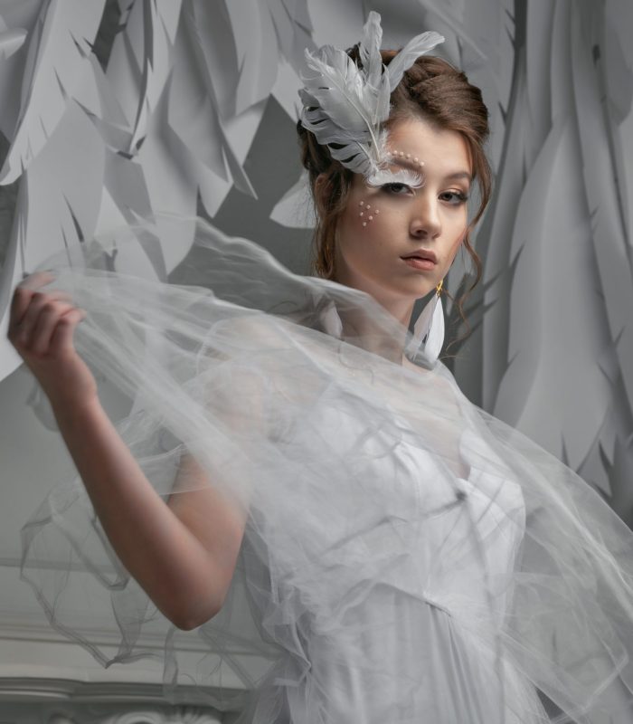 Elegant and gorgeous stylish model. Studio fashion and beauty portrait. Beautiful fashion model, creative white make up. Art concept. White swan or angel idea.